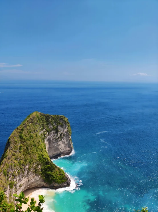 a small cliff with some water and a sandy beach