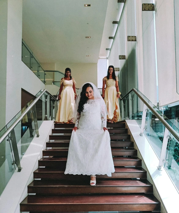 a woman wearing a white dress walking down a flight of stairs