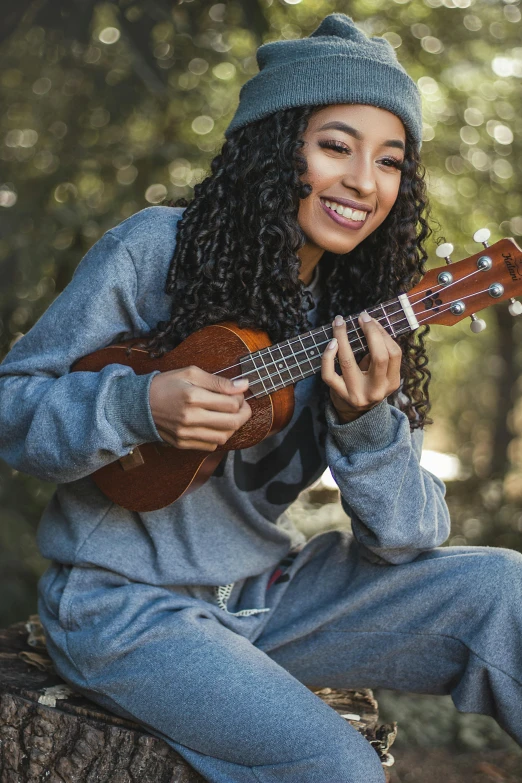 a woman holding a ukulele smiling at the camera