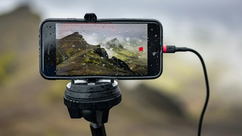 a smartphone is attached to a tripod with a microphone