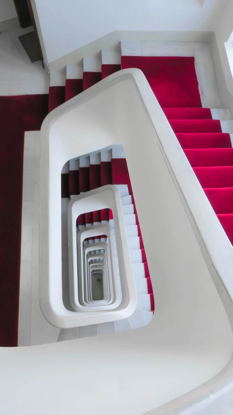 an aerial po looking down at a bright red stair with white railing