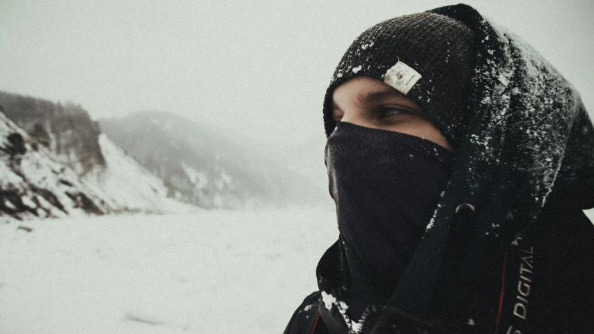 a woman stands in the snow with her eyes closed