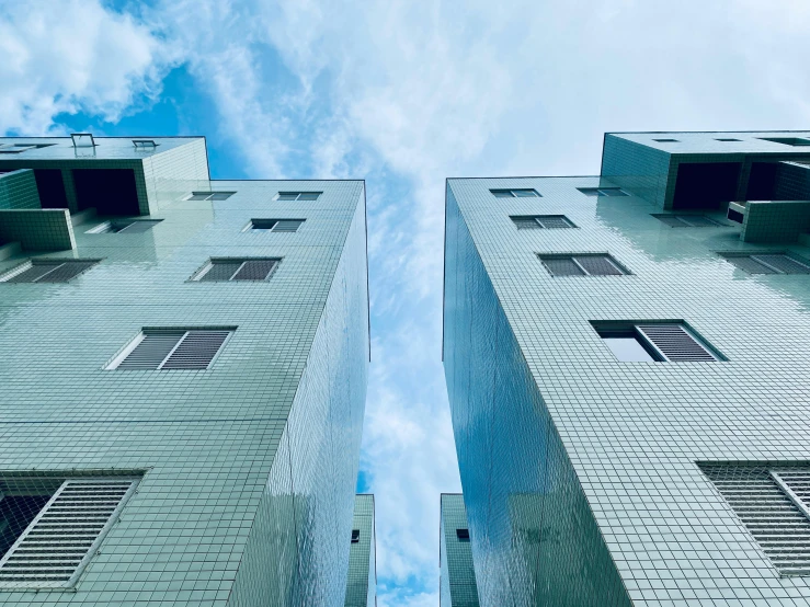 the side view of two tall buildings on a sunny day