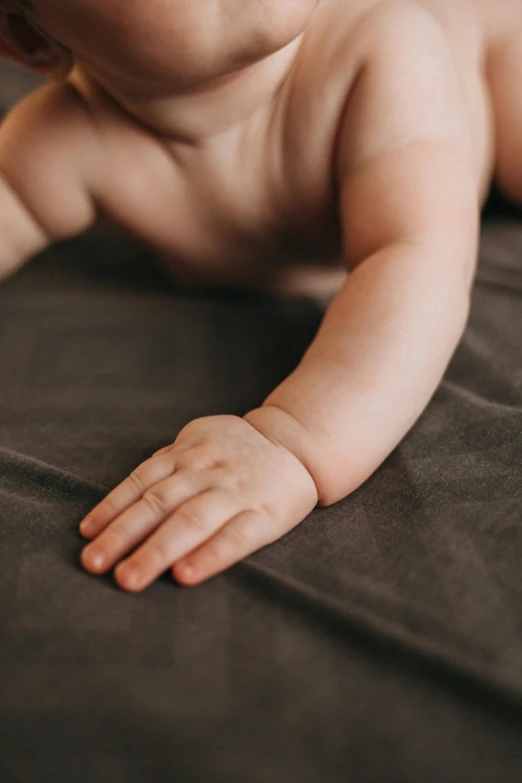 a  child laying on its side on a bed