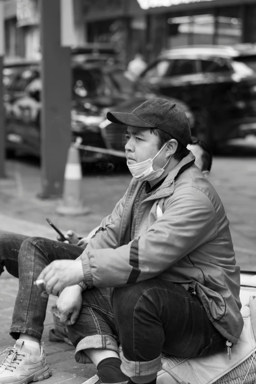 black and white po of a man wearing a face mask on the street