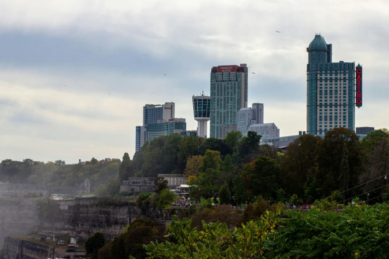 a city skyline on the other side of a waterfall