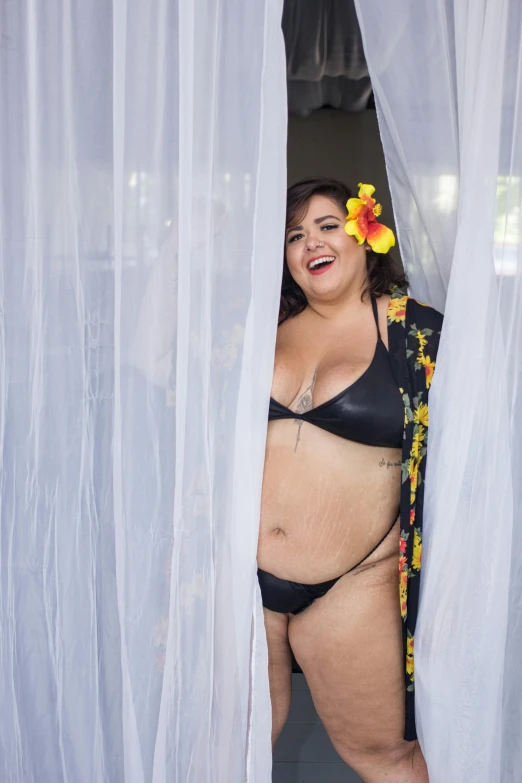 the fat woman in a bikini is peeking out of the curtain