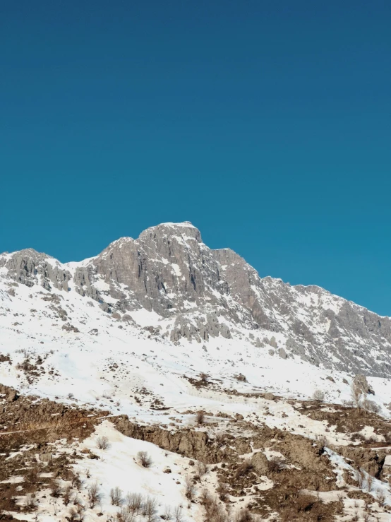 a big hill covered in snow under a blue sky