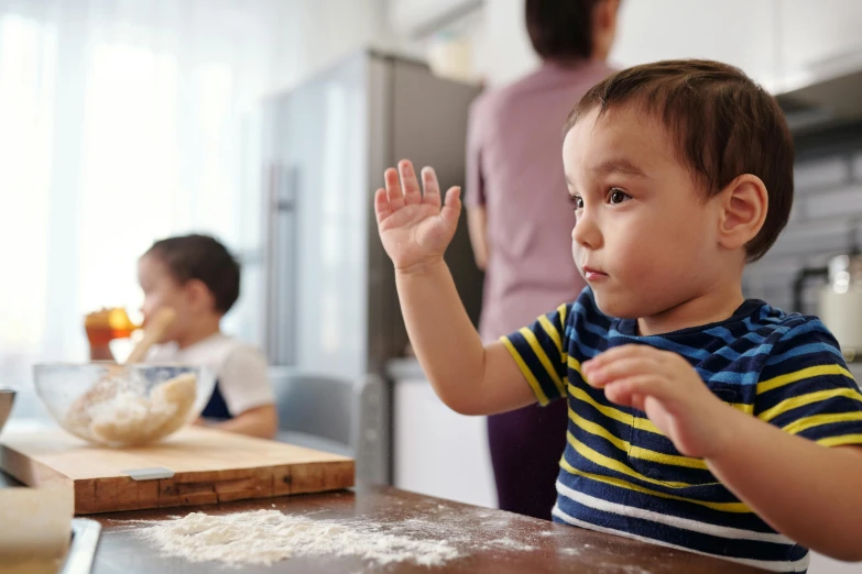 a little boy that is standing up in the kitchen