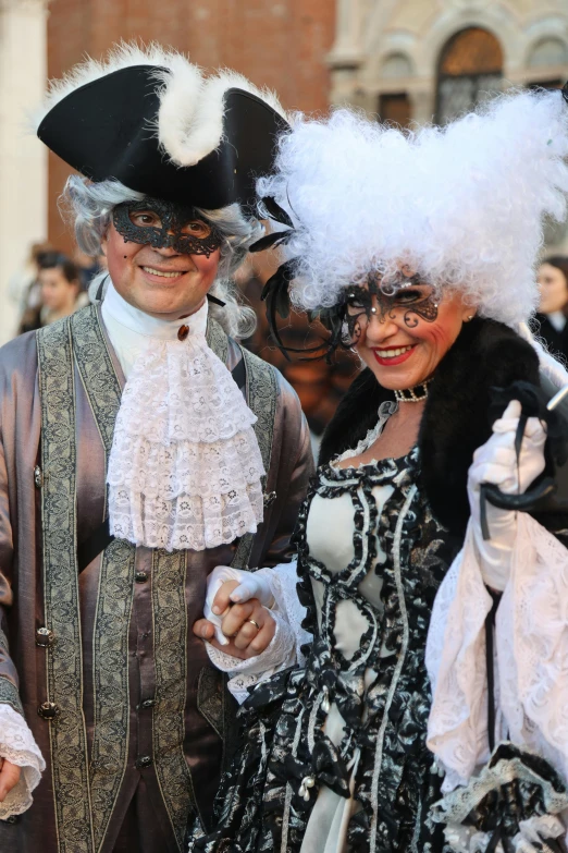 a man in costume and woman wearing black hat with white wig