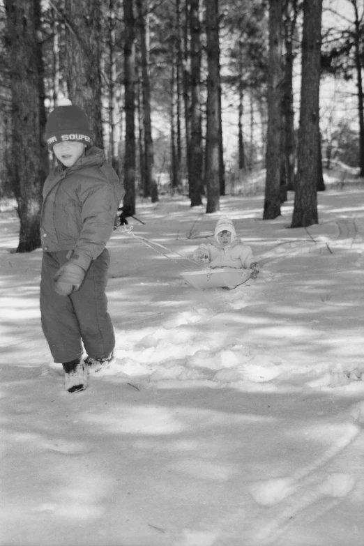 a boy snowboarding in the woods on a snowy day