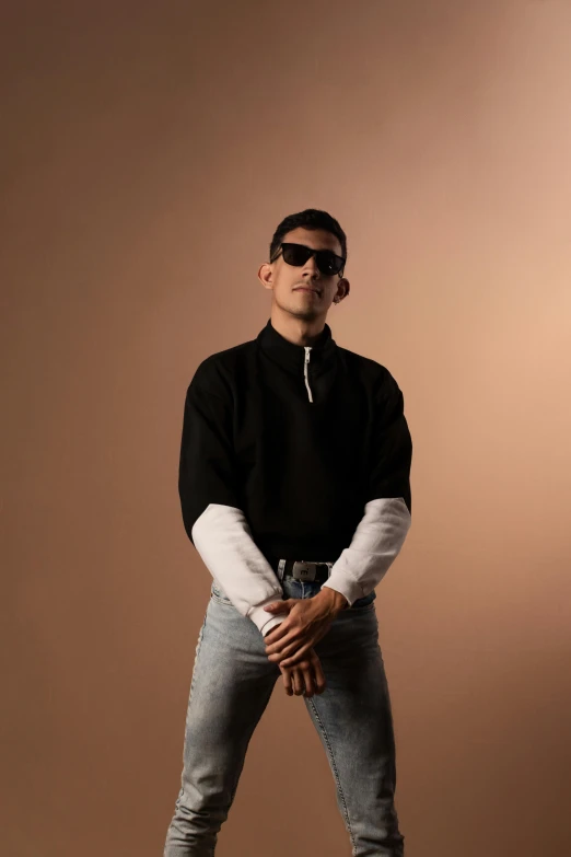 a man posing with sunglasses and a pair of jeans