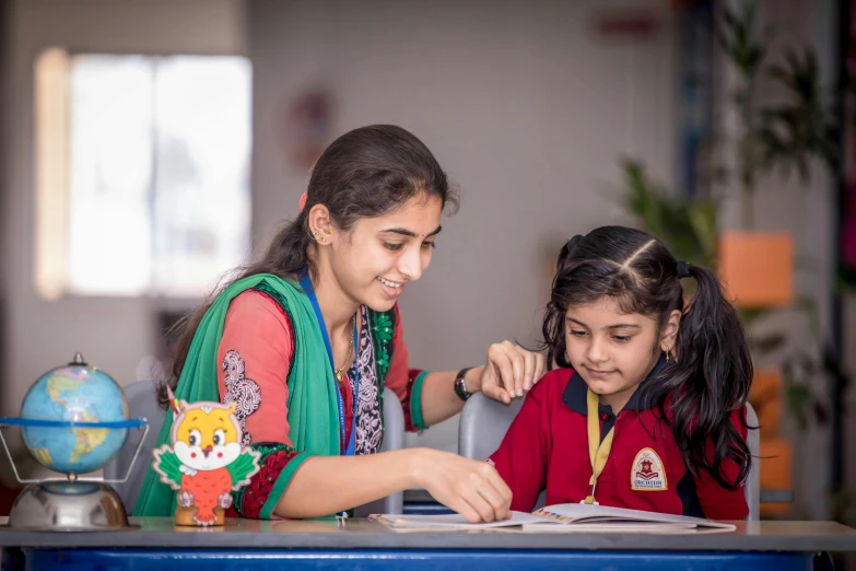 two schoolgirls work together on a project