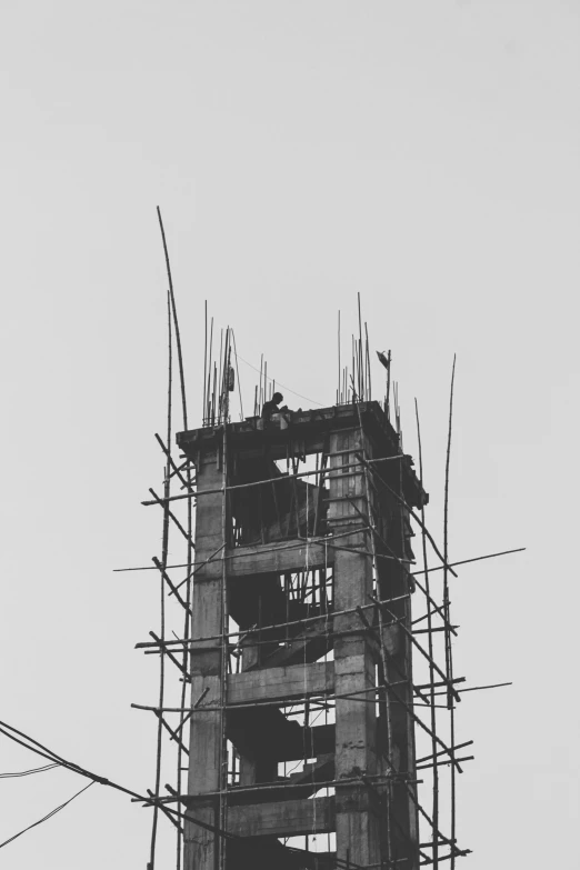 a tall building with scaffolding on top and some wire attached to it