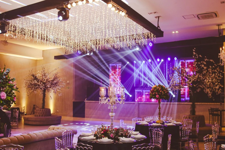 a banquet hall with table and chairs, flowers, and decorated centerpieces