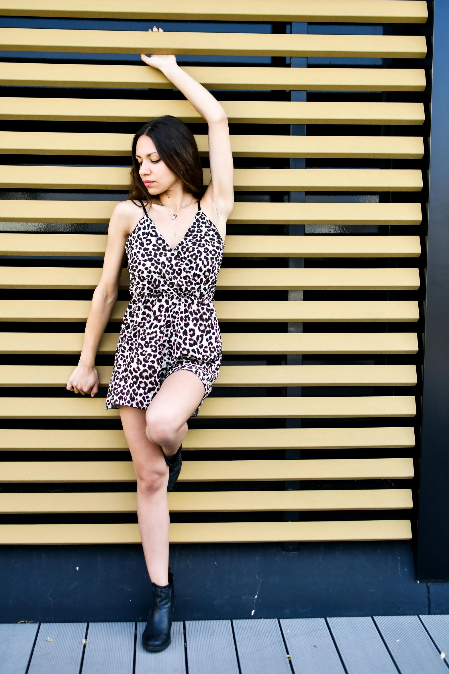 a woman in a short dress posing with her arms raised up