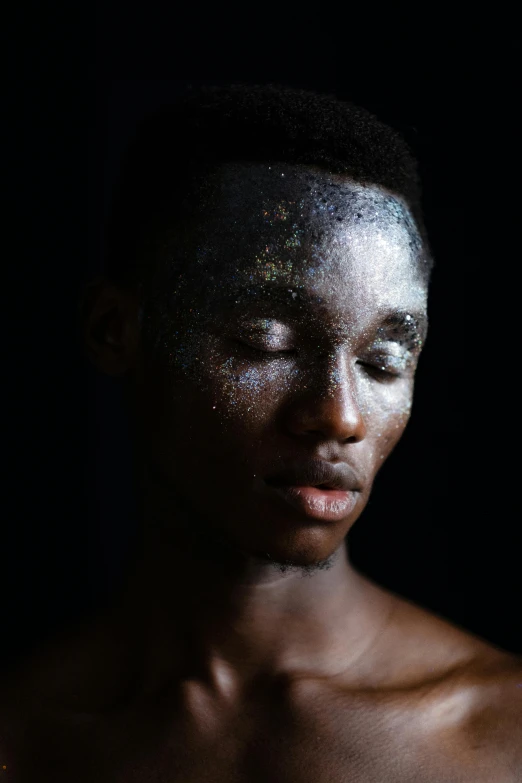 the image shows a man covered in silver glitter