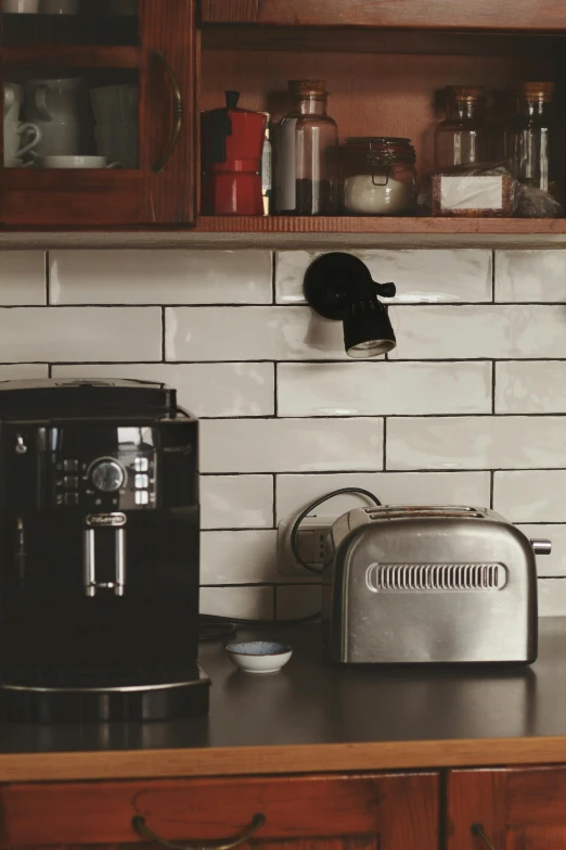 the black coffee machine is on the counter near a toaster