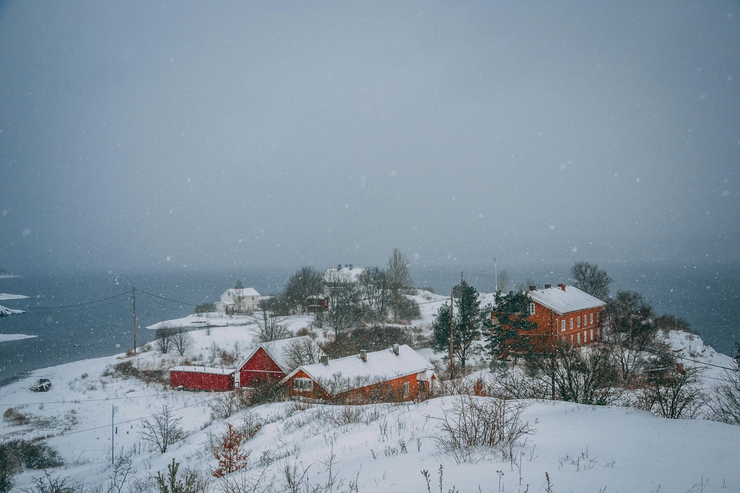 a view from the top of a hill of snow covered buildings