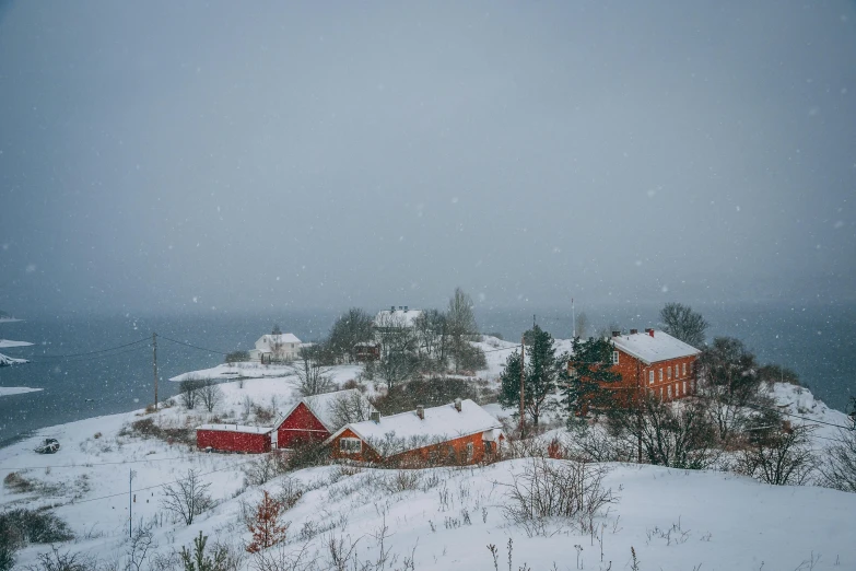 a view from the top of a hill of snow covered buildings