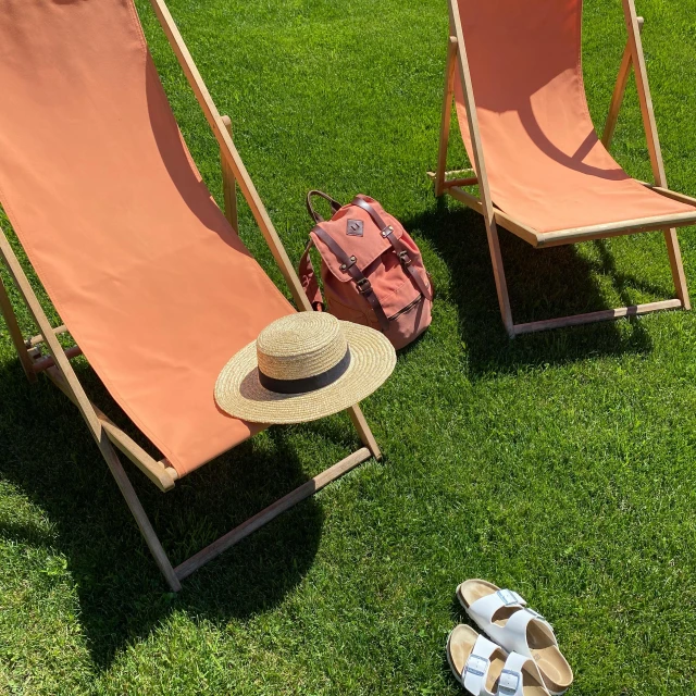 the two chairs are ready to sunbathe and relax in the grass