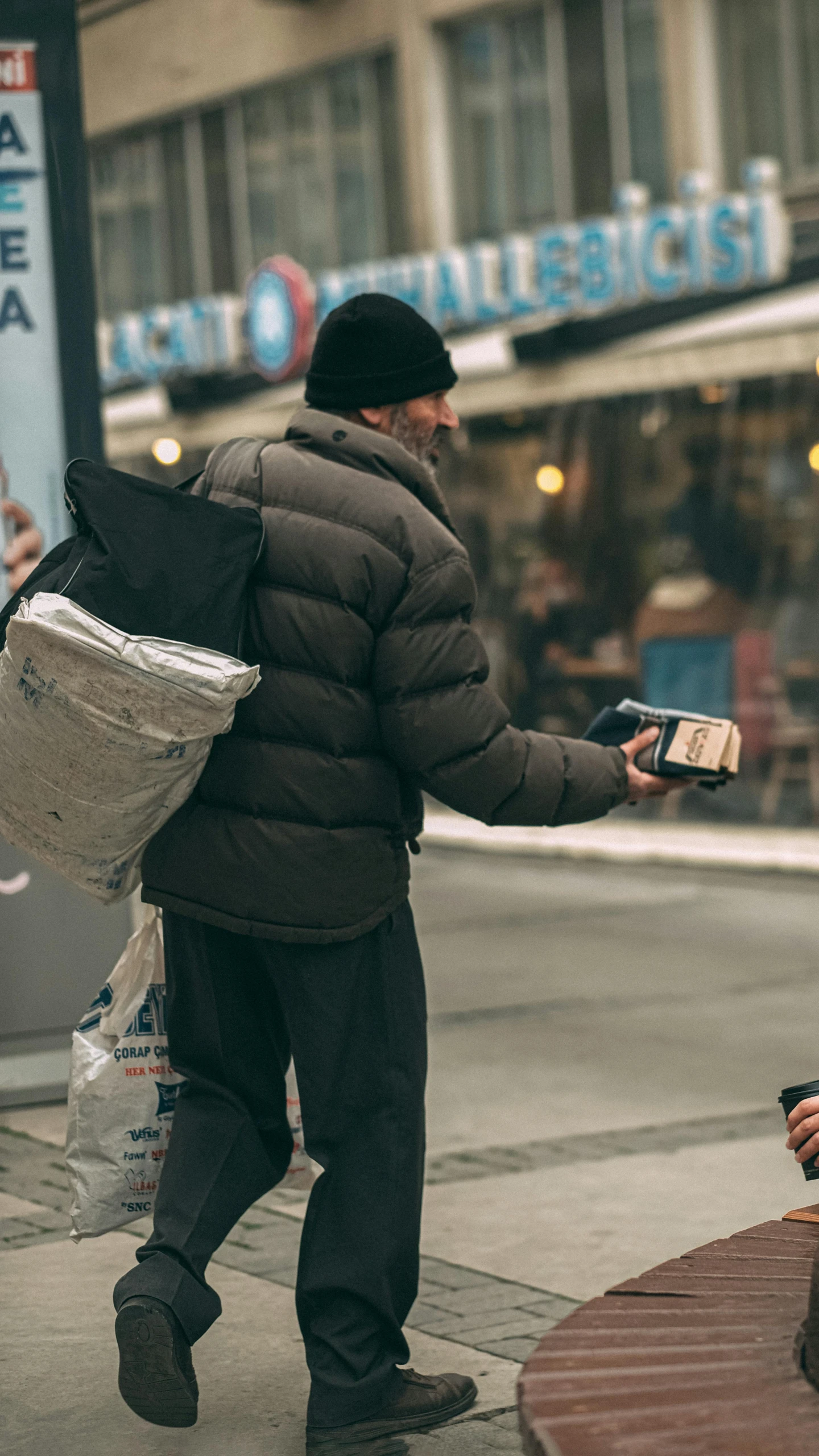 a man with a bag walks down a city street