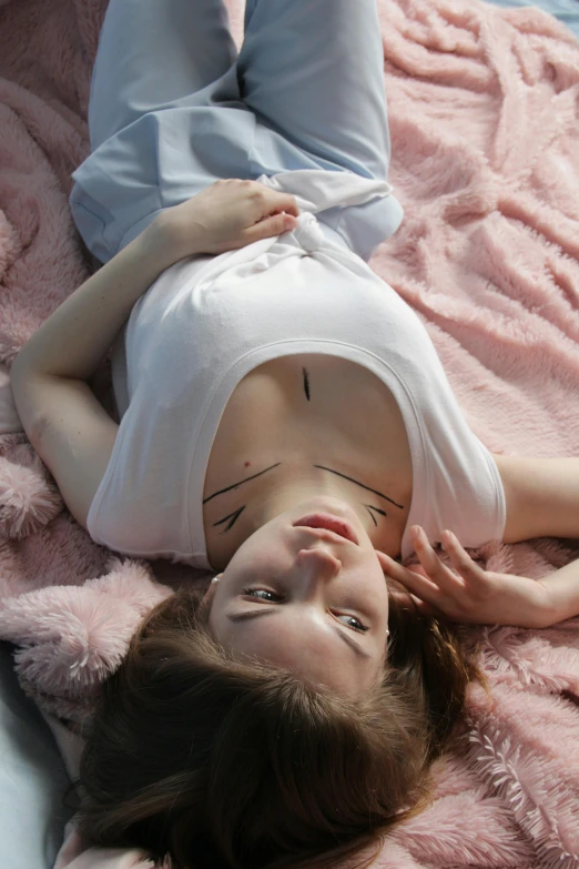 a young woman lays down with her face painted on