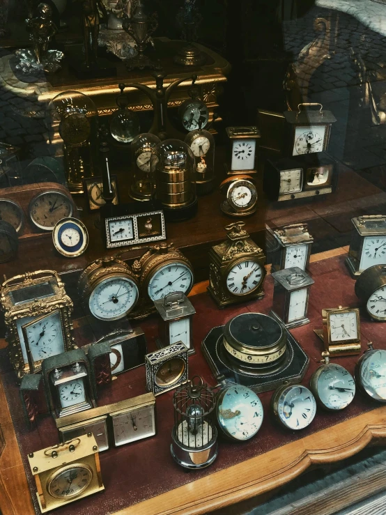 many old clocks sitting in the windows of a store