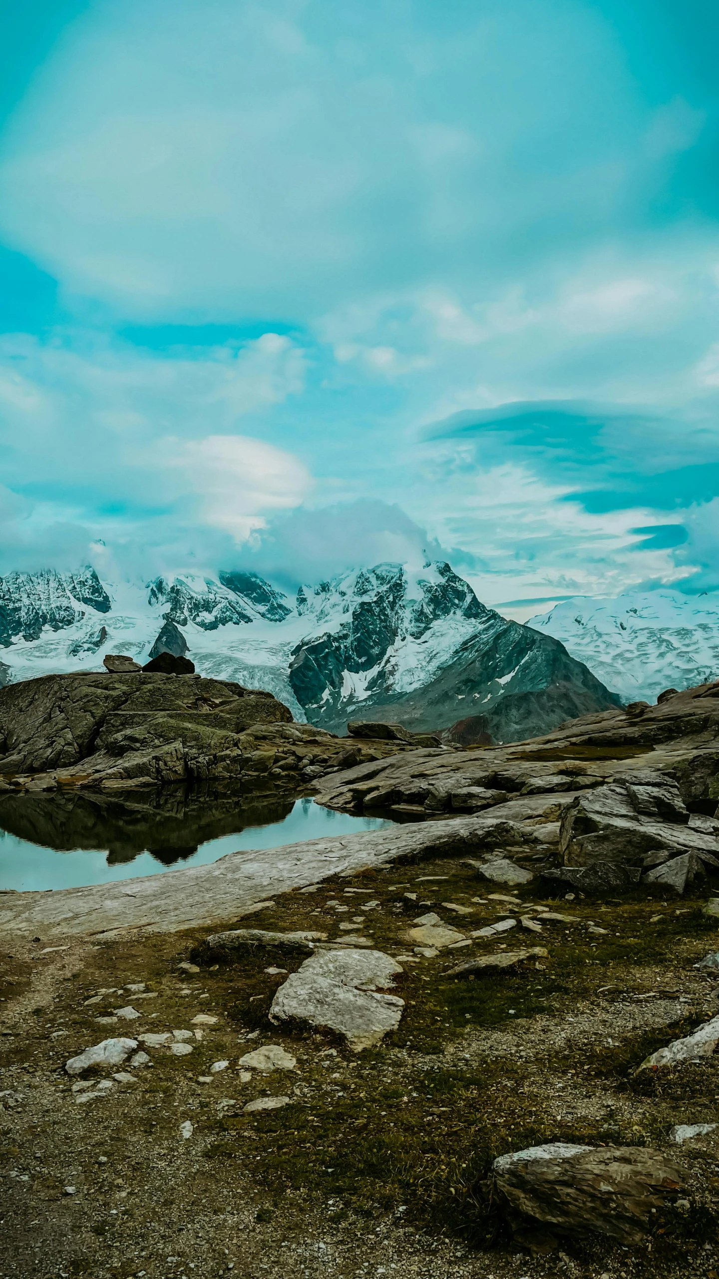 an open mountain range, with water surrounded by rocks