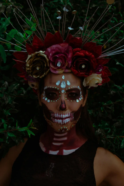 a woman has skeleton makeup with flowers and fake feathers