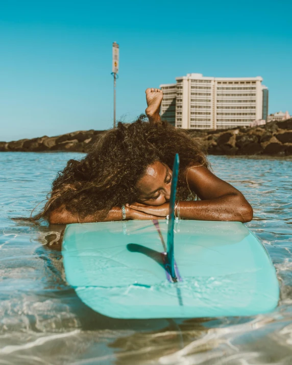 a beautiful woman riding on top of a surfboard in the ocean