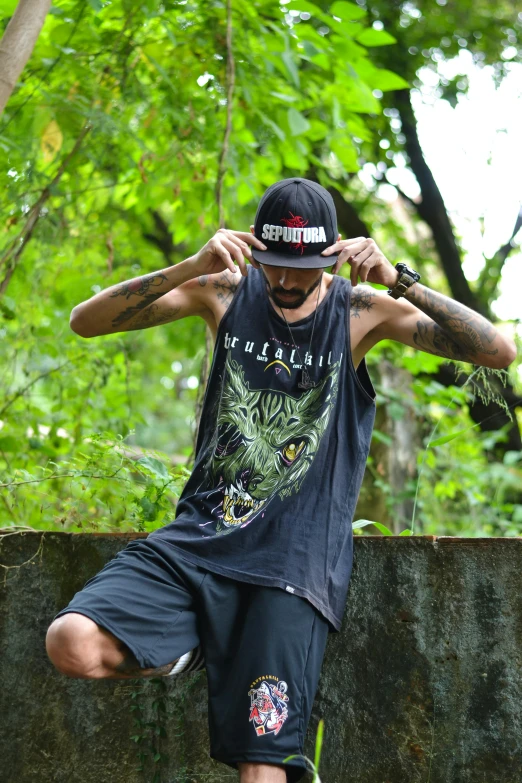 a person sitting on a fence with a baseball bat and some trees