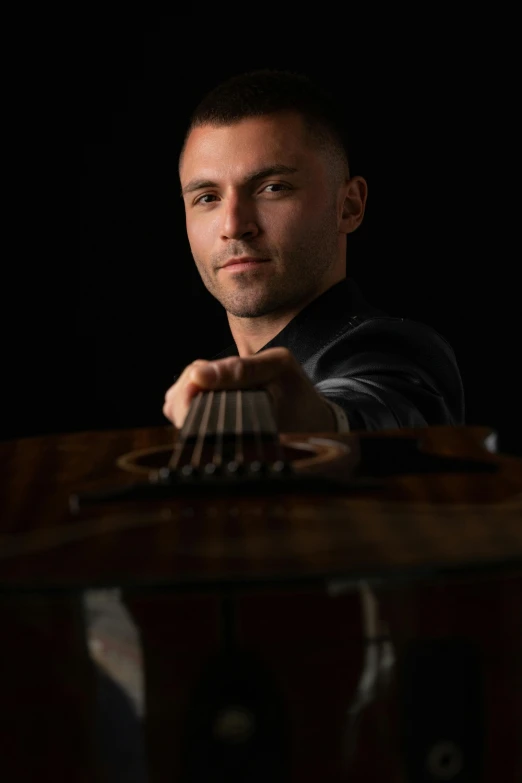 a man with a guitar on a table