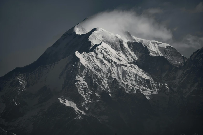 a mountain covered in snow and cloud in a black and white po