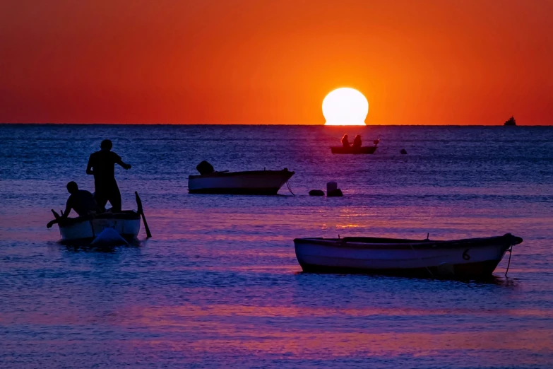 several boats are out on the water in the sunset