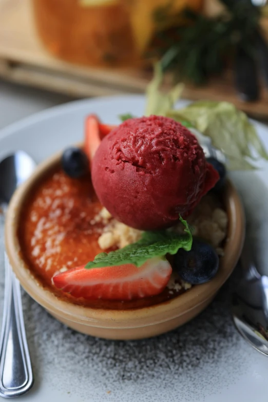 a bowl of food on a plate next to silverware