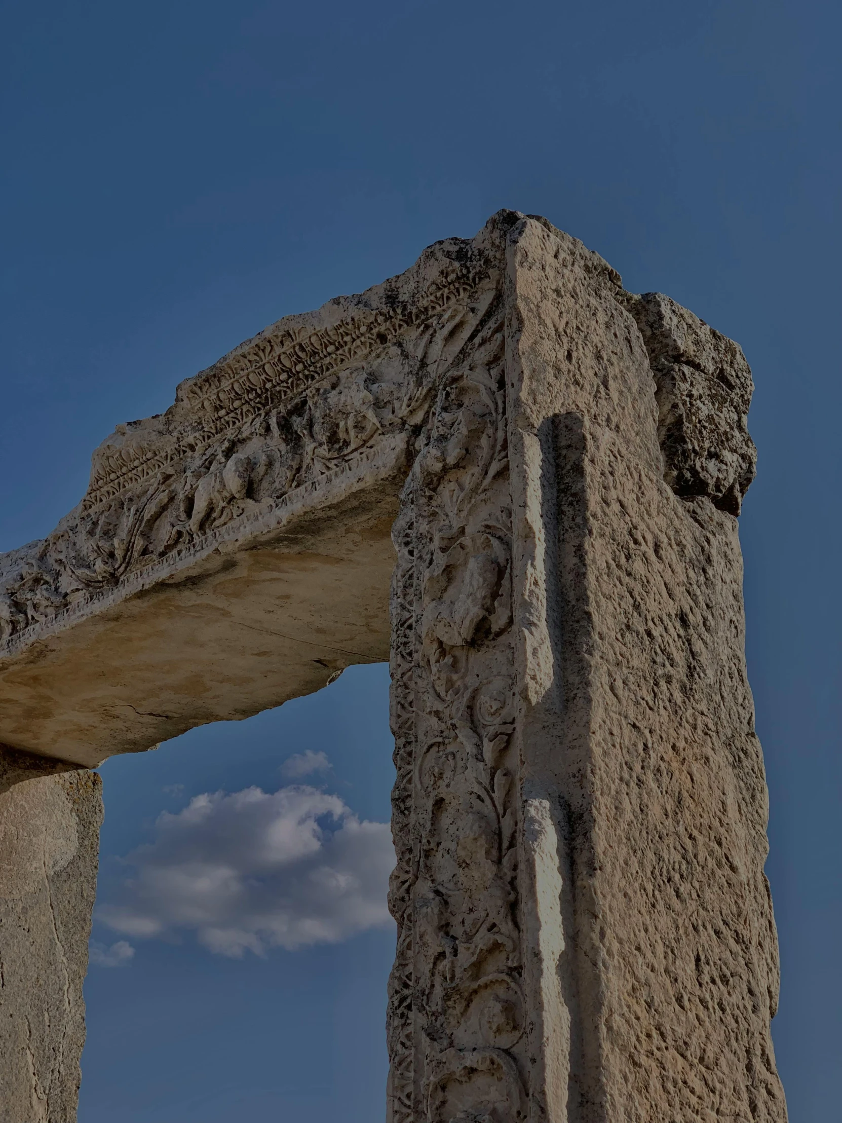 a stone arch with some rocks below it