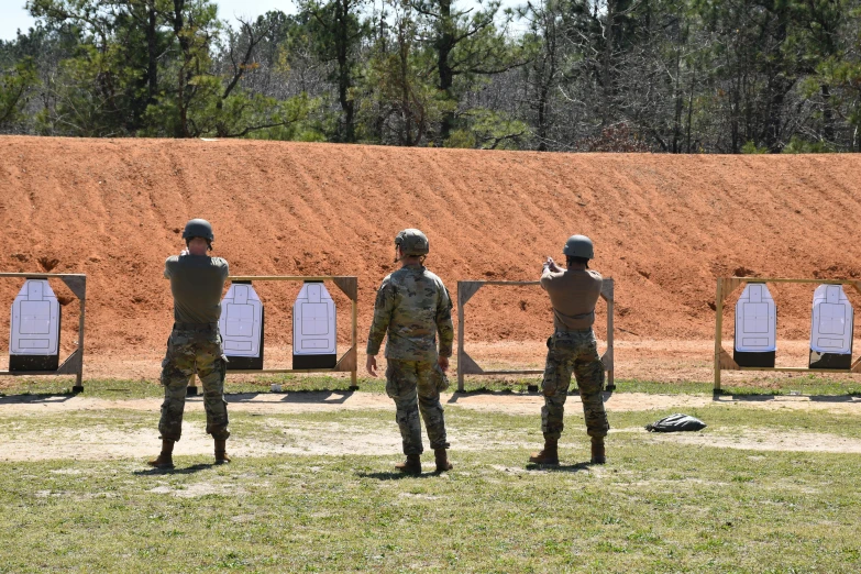 a bunch of men in the middle of shooting a range