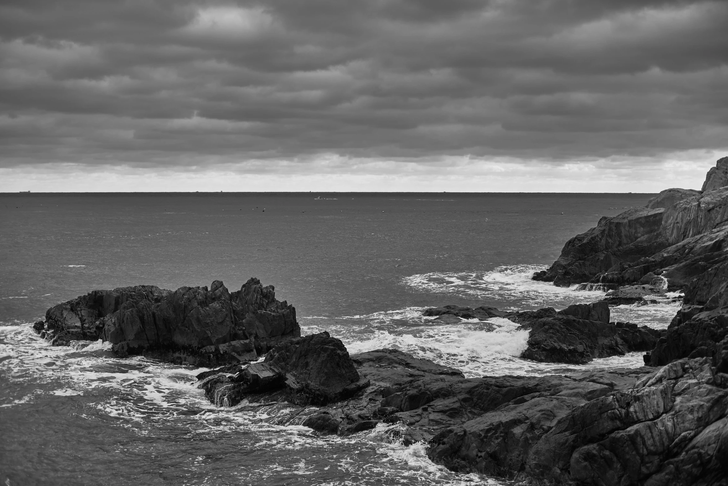 a lighthouse at the edge of a rocky ocean shore