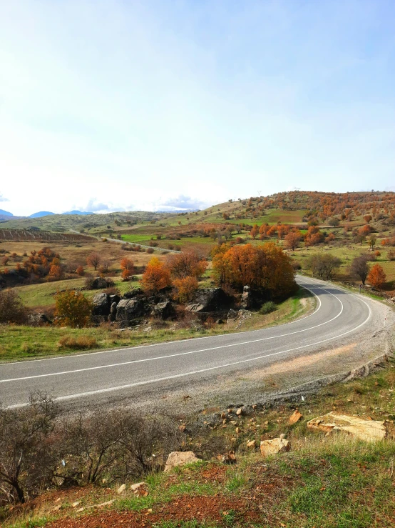 a winding road running through a green field