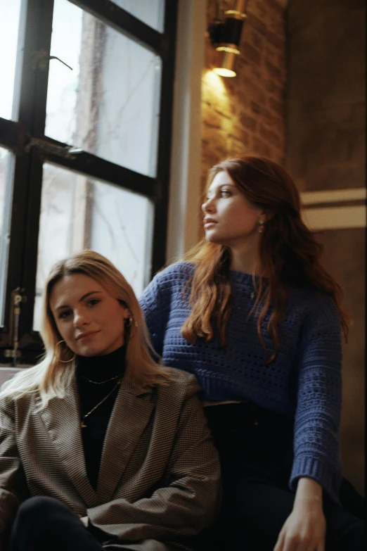 two women sit and look out the window