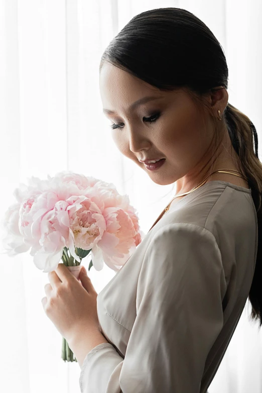 a woman looking down at a bunch of flowers