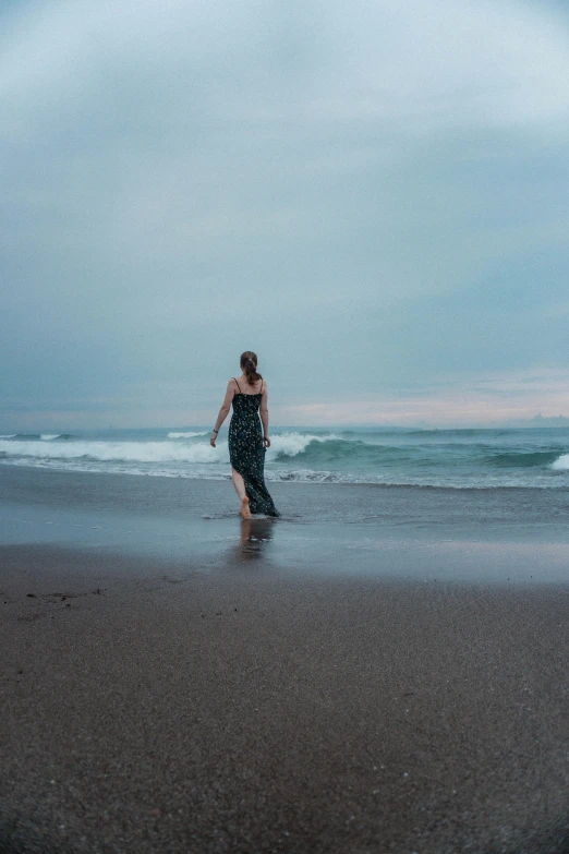 a person walking on a beach next to the ocean