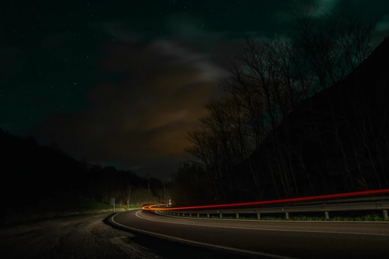 a blurry po shows the road with cars moving on it at night