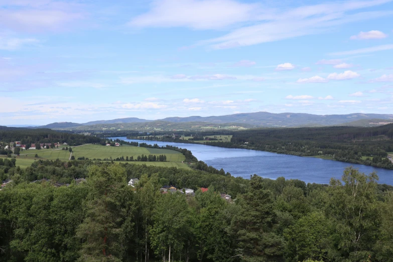 a lake surrounded by trees and green hills