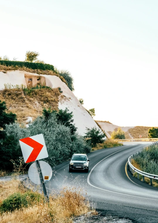 a sign that has a car on it sitting in the road