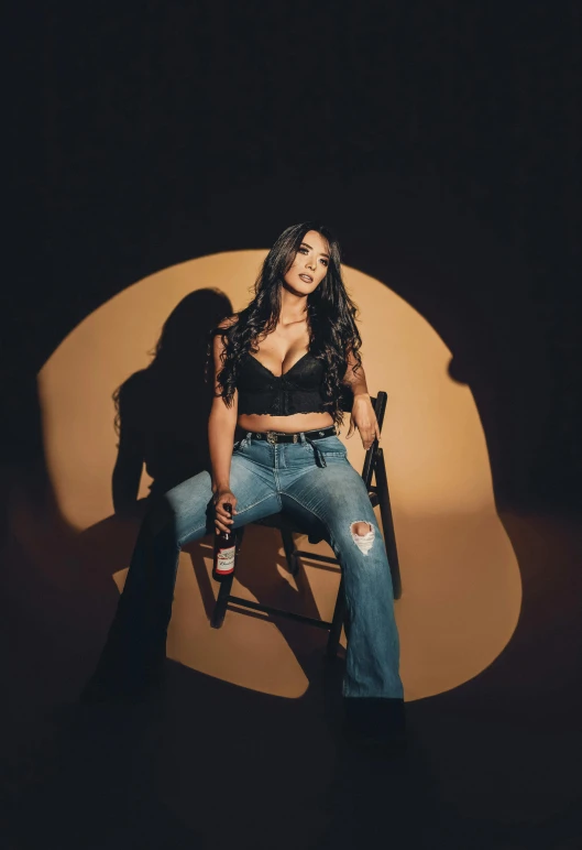 a woman in jeans and top sitting on a chair