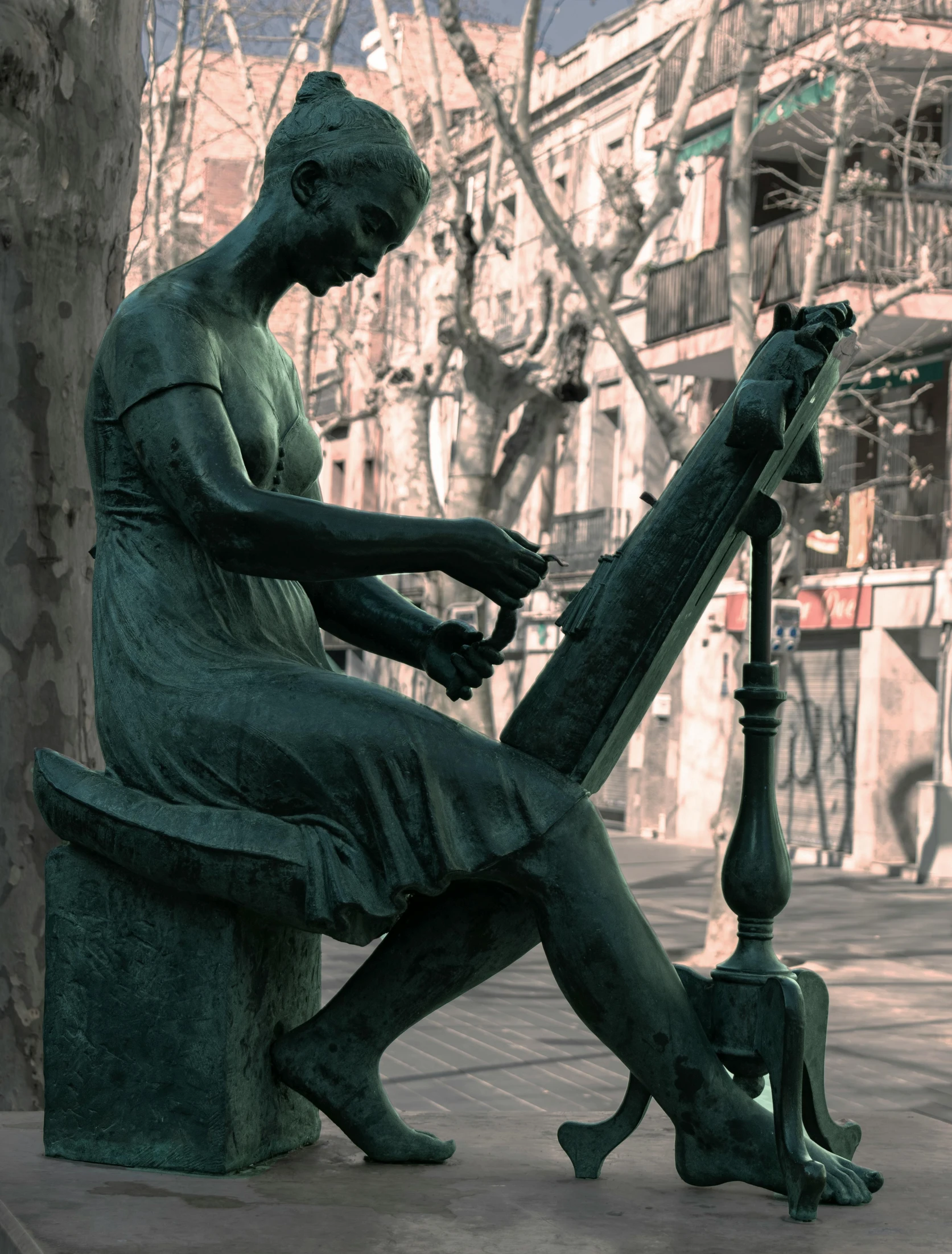 a statue holding a long instrument on a street corner