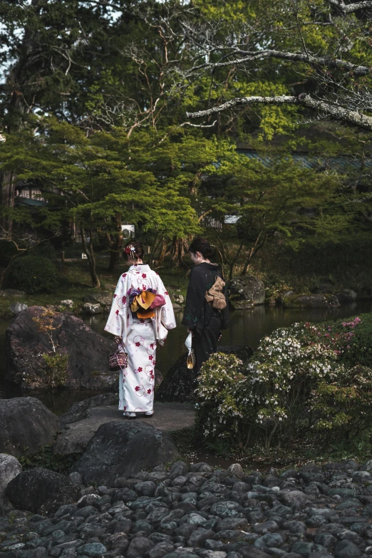 two men walk down a path, one in an asian costume