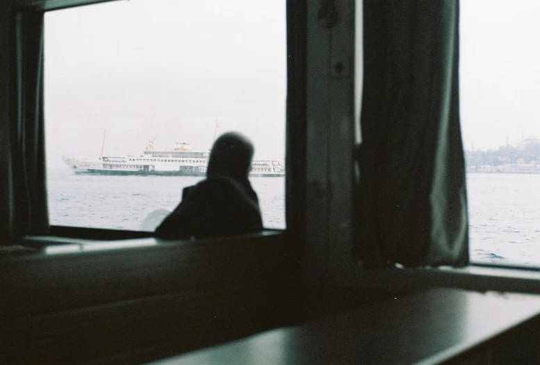 a woman looking out a window at the river